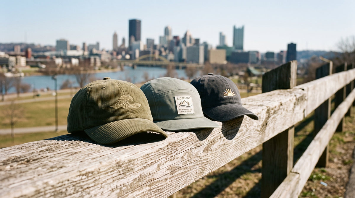 Three Fearless caps on a wooden fence rail